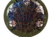 une image représentant une assiette décorative ornée de fleurs et de feuilles