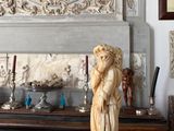 a statue of a woman holding an umbrella on a mantle