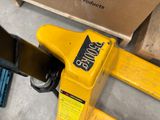 a yellow hand tool that is sitting on top of a pallet