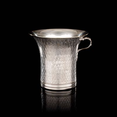 pichet en verre plaqué argent posé sur une surface noire avec reflet