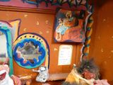 une petite maison de poupées avec une poupée et un miroir accroché au mur