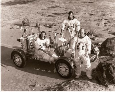 des astronautes posant devant un véhicule à la surface de la Lune