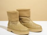 une paire de bottes beiges recouvertes d'une chaussette tricotée