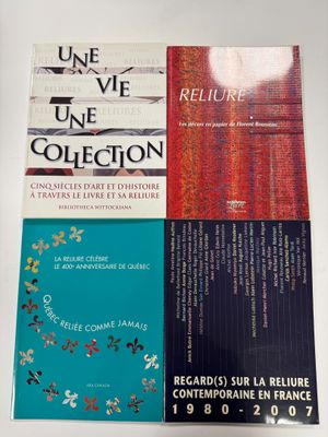 trois livres sont empilés sur une table