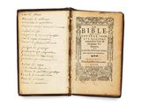un vieux livre sur lequel on peut lire des mots, ouvert sur une surface blanche