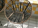 two wicker chairs sitting on a tiled floor next to a window