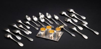 un ensemble d'argenterie composé de cuillères et de fourchettes, présenté sur un plateau