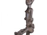 statue of a person sitting on a stool with a dog