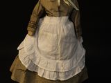 an old fashioned doll of a woman in a dress and bonnet on a black background