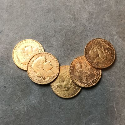 plusieurs pièces d'or posées les unes à côté des autres sur une table