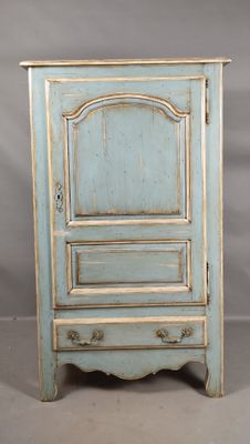 une vieille armoire bleue avec une porte et un tiroir au-dessus