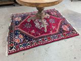 une petite table avec un plateau en bois sur un tapis