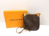 un sac à main Louis Vuitton et une boîte posés sur une table