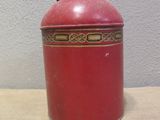 a red vase sitting on a table with a white wall in the background