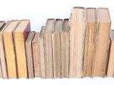 many books stacked on top of each other on a table