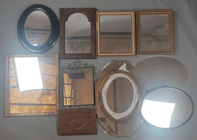 many mirrors and frames on the wall in this room
