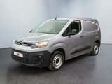 La camionnette grise est garée dans la pièce vide de l'immeuble.