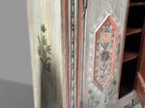a wooden cabinet with a door and a shelf on top of it