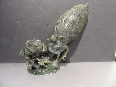 a statue of a bird with a flower on a table