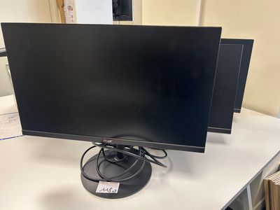 a couple of monitors sitting on top of a table next to each other