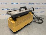 a close up of a yellow machine on a gray surface
