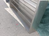 a metal bench that is sitting on the side of the road