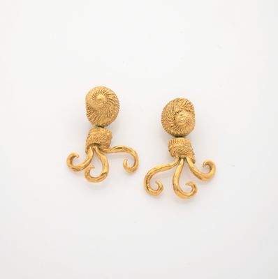 an image of a pair of gold octopus earrings on a white surface