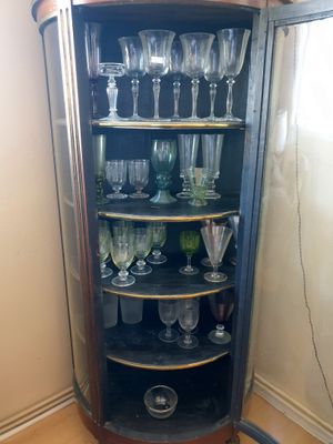 une armoire d'angle sur laquelle sont posés des verres à vin
