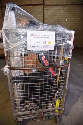 a cart full of luggage in a warehouse with a sign on top of it