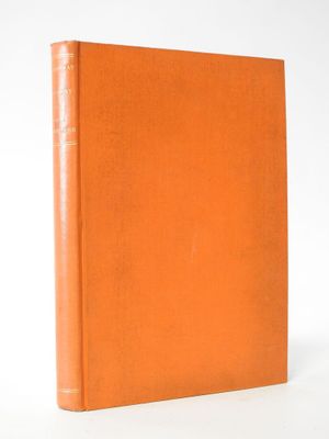 an orange book sitting on top of a white surface