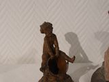 two figurines of a man and a woman sitting on top of each other