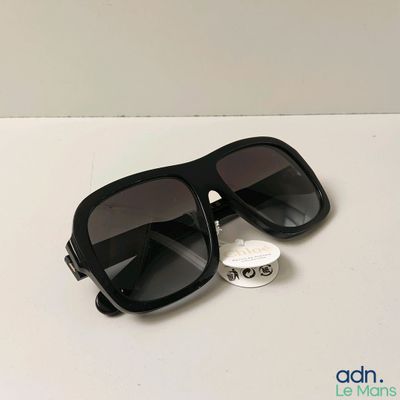 black sunglasses on a white table with a tag on it