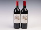 two bottles of red wine sitting next to each other on a table