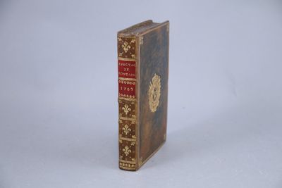 un vieux livre posé sur une table à côté d'un fond blanc