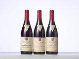 three bottles of red wine sitting on top of a table