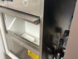 a small refrigerator with a lot of toothbrushes and a bottle of alcohol