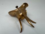 an image of a brass elephant head on a white surface