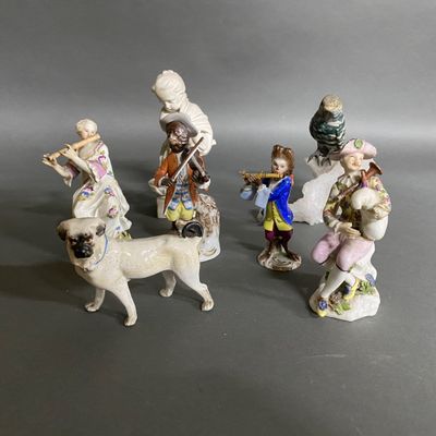 three figurines of people and a dog on a gray surface