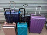 Plusieurs bagages sont alignés contre la porte du garage.