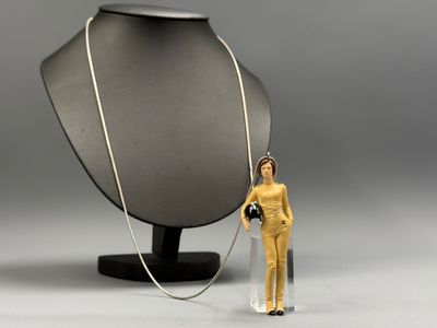 une figurine représentant une femme tenant un appareil photo à côté d'un mannequin