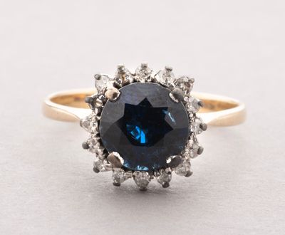 a close up of a blue sapphire and diamond ring