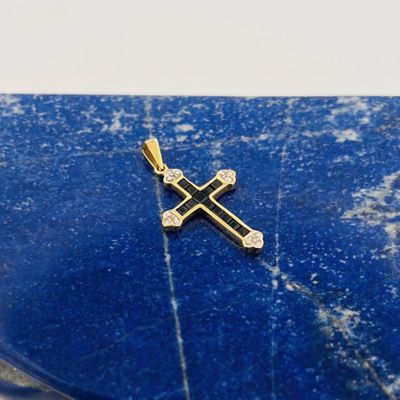 un gros plan d'une croix en or posée sur une dalle de marbre bleu