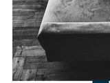 black and white photograph of a couch in a room with wood flooring