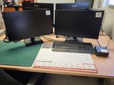 un bureau équipé de deux écrans et d'un clavier