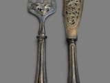 two forks and a knife on a gray surface