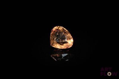 un diamant jaune dans l'obscurité, dont la surface reflète la lumière