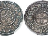 a close up of two silver coins on a white surface