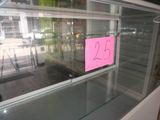 a glass display case with a pink sticker on it