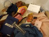a box full of clothes and other items on a bed