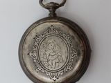 a silver pocket watch with a picture of a woman on it